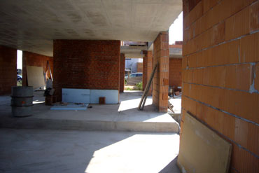 Otevřený prostor budoucího obytného pokoje - vlevo nika na kuchyň, uprostřed jídelna s východem na terasu.