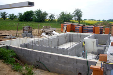 Po provedení hydroizolací a provedení základové desky mohla být dokončena konstrukce ŽB vany budoucího interiérového bazénu, vpravo je vidět budoucí akumulační nádrž pro přepadový kanálek bazénu.