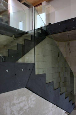 Skleněné zábradlí je uchyceno k ŽB konstrukci schodiště za pomoci skrytých ocelových plechů.
