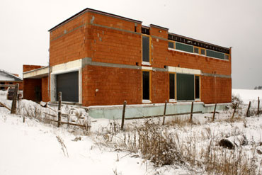Celkový zimní pohled na dům s okny ze silnice (východní strana).