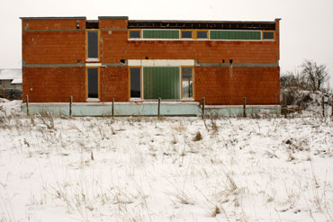 Celkový zimní pohled na dům s okny ze sousedního pozemku (severní strana).