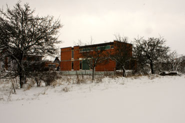 Celkový zimní pohled na dům s okny z pole (západní strana).