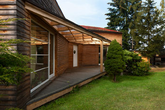 Zastřešená vstupní a obytná terasa propojuje interiér domu s rozlehlou zahradou