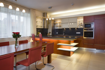 Interiér obytného prostoru, v popředí jídelní stůl a židle MARTENA VAN SEVERENA z Vitry, vzadu kuchyňský kout se servírovacím pultem