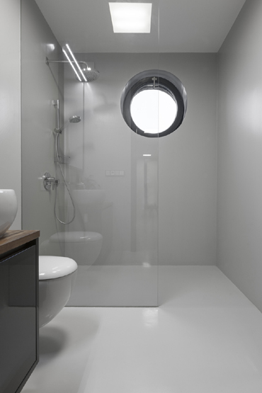 Dolní koupelna se sprchovým koutem a WC má na podlaze i na stěnách epoxidovou stěrku