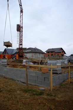 Spodních 0,6 m výšky základových pasů je provedeno z prostého betonu přímo do vykopané rýhy. Vyšší část základu až pod základovou desku je provedena z betonových bednicích dílců šířky 300 mm vyplněných prostým betonem a vyztužené výztuží v každé dutině.