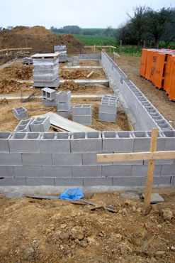 Spodních 0,6 m výšky základových pasů je provedeno z prostého betonu přímo do vykopané rýhy. Vyšší část základu až pod základovou desku je provedena z betonových bednicích dílců šířky 300 mm vyplněných prostým betonem a vyztužené výztuží v každé dutině.